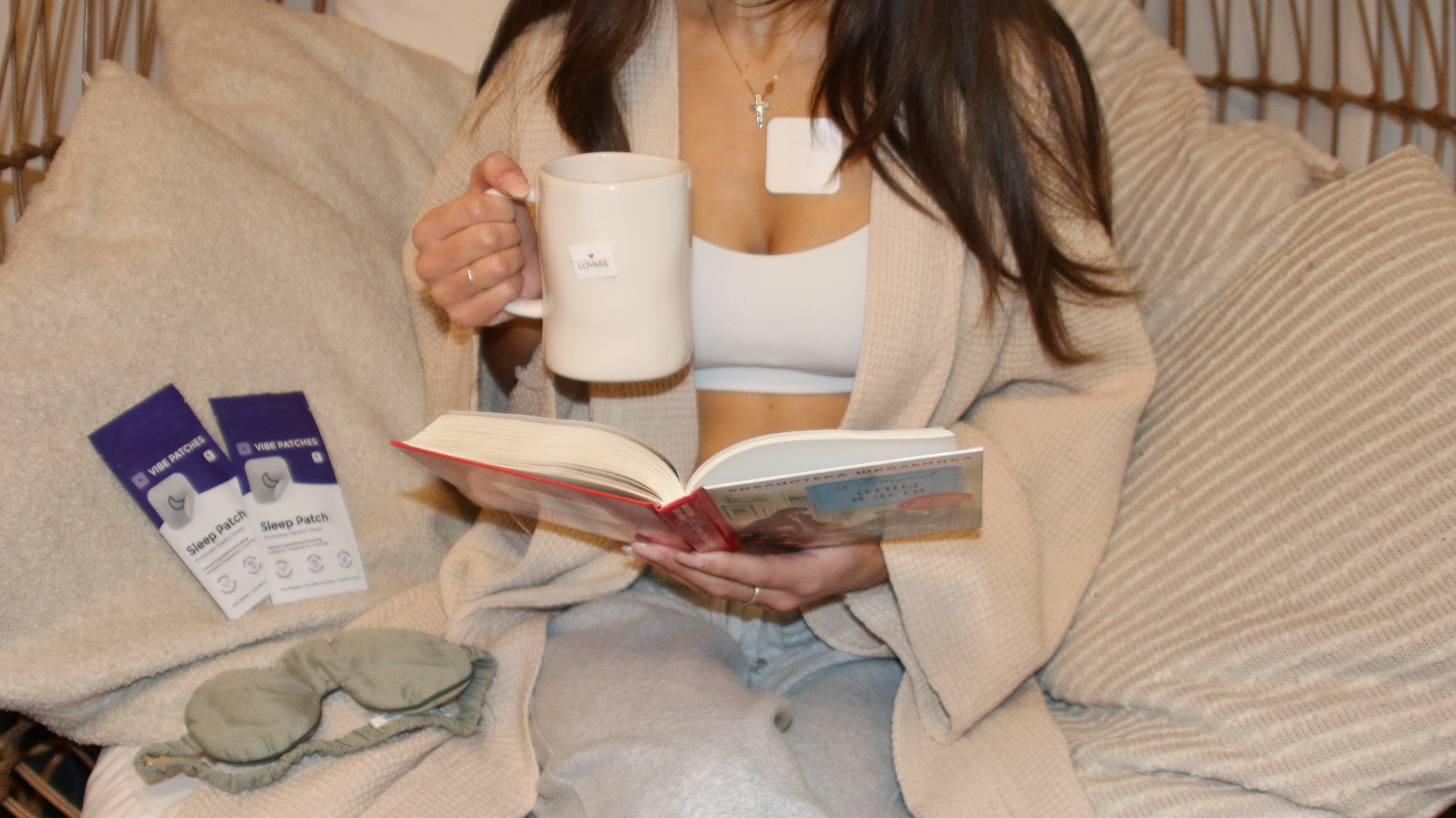 A woman sitting on a hammock drinking coffee with Vibe Patches products.
