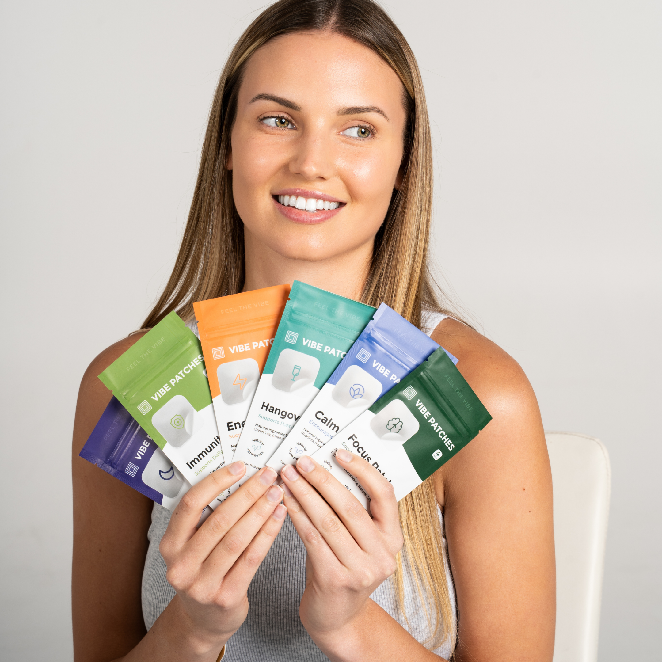 An image of a woman holding up vitamin patches